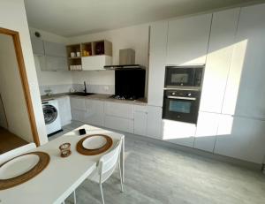 a white kitchen with a table and a microwave at Coockooning Led in Basse-Yutz