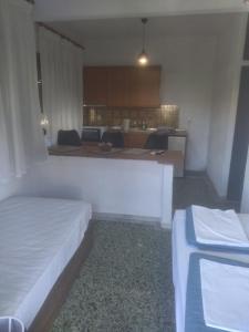 Habitación con 2 camas y cocina con encimera. en PELEKAN rooms and apartments ATHINA 23, en Pefkohori
