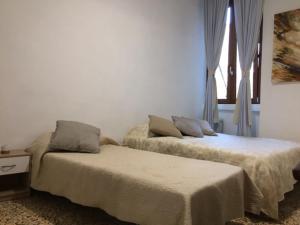 dos camas sentadas una al lado de la otra en una habitación en Appartamentino in Piazza en Trevignano Romano