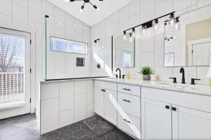 ein weißes Bad mit 2 Waschbecken und einem großen Fenster in der Unterkunft Modernized Picturesque Lonestar Property with Priv in Nampa