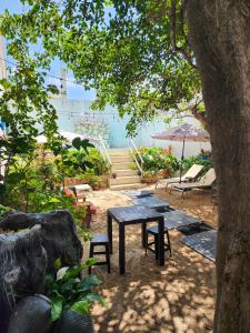 uma mesa de piquenique com cadeiras e um guarda-sol na praia em Antillas em Isla Mujeres