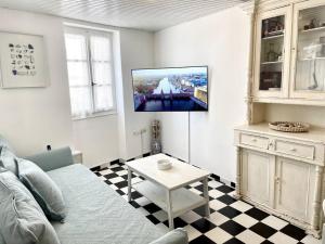 Sunset Haven في بوروس: غرفة معيشة مع أريكة وتلفزيون على الحائط