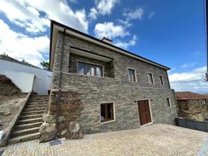 a stone house with a staircase leading up to it at Casa da Portelinha in Castelo de Paiva