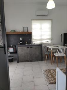 cocina y comedor con mesa y sillas en Galini Rooms & Apartments, en Finikas