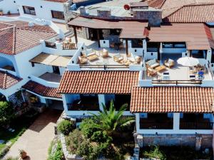 an aerial view of a house with chairs on the roofs at Hotel Pedra Santa in Baja Sardinia