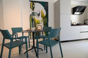 a dining room with a table and chairs and a painting at Lebum Apartments & Suites in Marsala