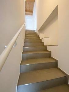 una escalera en una casa con escaleras grises en B&B Profumo Di Gelsomino en Mombaroccio
