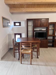 a dining room with a wooden table and chairs at La Piazzetta in LʼAquila