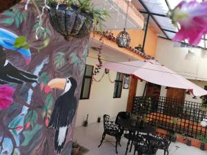 una pared con un pájaro pintado en ella junto a una mesa en Hotel Amayal en San Cristóbal de Las Casas