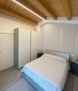 B&B Profumo Di Gelsomino في Mombaroccio: غرفة نوم مع سرير وخزانة بيضاء
