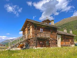 una vecchia baita di tronchi in un prato di Chalet I Clus a Livigno
