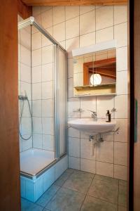 a bathroom with a sink and a shower at Kulinarik & Geniesser Hôtel STRAUSS in Fiesch