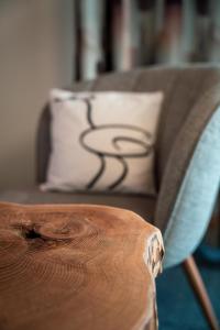 ein Sofa mit einem Kissen und einem Holztisch in der Unterkunft Kulinarik & Geniesser Hôtel STRAUSS in Fiesch