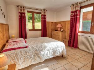 una camera da letto con un letto con tende rosse e una finestra di Appartement cosy 3 pièces au pied des pistes, parking privé - FR-1-505-104 a Notre-Dame-de-Bellecombe