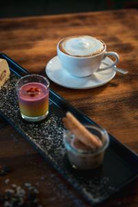 eine Tasse Kaffee auf einem Tablett mit einer Tasse Kaffee in der Unterkunft Kulinarik & Geniesser Hôtel STRAUSS in Fiesch