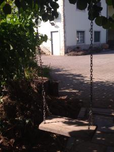a swing in a courtyard with a building at Cantinho Verde in Sertã