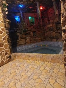 une baignoire jacuzzi dans une maison en pierre la nuit dans l'établissement Cabana Micutu, à Sebeş