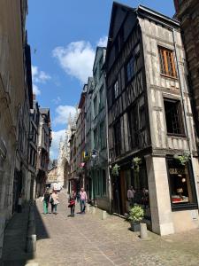 um grupo de pessoas andando por uma rua com edifícios em Le Graveur Saint Maclou, Hyper centre, Typique Rouennais em Rouen