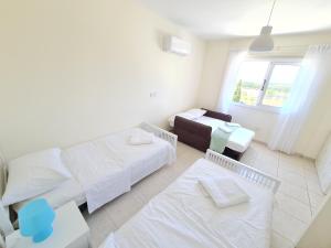 un soggiorno con 2 letti e un divano di Stunning views' Apartment with Pool a Paphos
