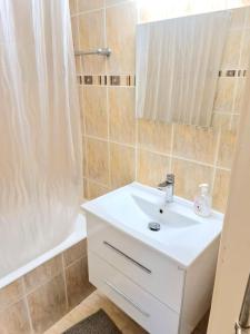 Un baño con lavabo blanco y ducha. en Stunning views' Apartment with Pool, en Pafos