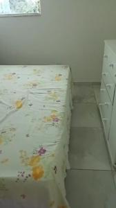a bed with a floral sheet on the floor in a room at Casa Duplex - Garanhuns in Garanhuns