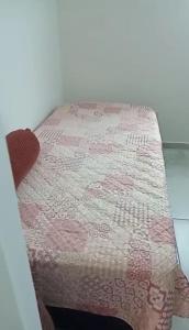 a bed with a quilt on top of it at Casa Duplex - Garanhuns in Garanhuns
