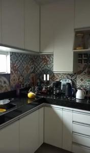 a kitchen with white cabinets and black counter tops at Casa Duplex - Garanhuns in Garanhuns