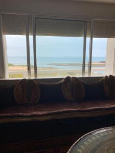 een bank voor een raam met uitzicht op het strand bij marina beach mohammedia in Mohammedia
