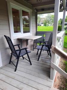 a screened porch with a table and chairs on it at Atpūta pie upītes in Krāslava