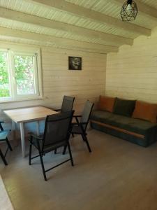 a living room with a couch and a table and chairs at Atpūta pie upītes in Krāslava +11 photos