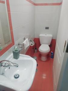 a bathroom with a white sink and a toilet at Sia's house near to airport in Artemida