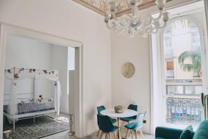 a living room with a chandelier and a table and chairs at Appartamenti Luxury Greco in Brindisi