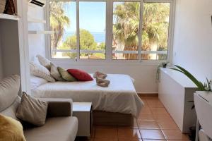 sala de estar con cama, sofá y ventanas en La ventana de Puerto Marina, en Benalmádena
