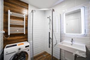 a bathroom with a washing machine and a sink at Sunshine Dream Apartments in Batumi