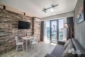 Sunshine Dream Apartments في باتومي: غرفة معيشة مع أريكة وطاولة