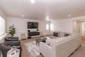 a living room with a couch and a tv at Stunning 5 Bedroom Rexburg Home in Rexburg