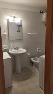 een witte badkamer met een wastafel en een toilet bij CASA VACANZE ARBORIAMAR SORSO SARDEGNa in Marina di Sorso