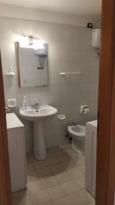 a white bathroom with a sink and a toilet at CASA VACANZE ARBORIAMAR SORSO SARDEGNa in Marina di Sorso