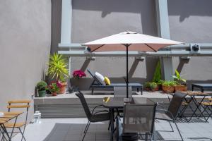 a patio with tables and chairs and an umbrella at DuMont Lisbon Guesthouse in Lisbon