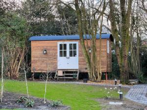 uma pequena cabana de madeira num quintal com árvores em Tranquil Spot Shepherds Hut em Cinderford