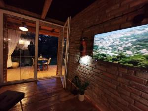 a living room with a tv on a brick wall at DOMAGAŁA domek całoroczny in Łagów