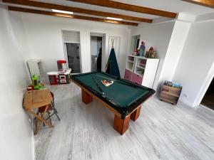 una sala de estar con una mesa de billar. en Maison familiale 4 chambres avec jardin et piscine en Saint-Aignan-Grand-Lieu