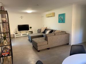 ein Wohnzimmer mit einem Sofa und einem TV in der Unterkunft Sylvan Seas in Bellara