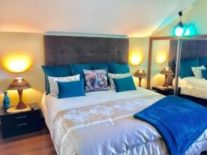 a blue bedroom with a large bed with blue pillows at Villa Safari Charm in Ribeira Brava