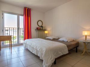 een slaapkamer met een bed en een groot raam bij Appartement Mèze, 4 pièces, 6 personnes - FR-1-604-5 in Mèze