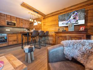 a living room with a couch and a kitchen with a tv at Appartement rénové au cœur de l'Alpe d'Huez avec Wifi et Parking - FR-1-645-24 in LʼHuez