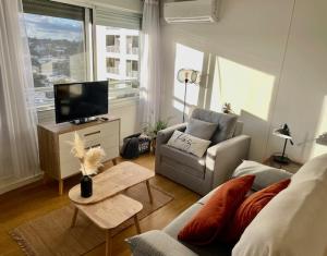 ein Wohnzimmer mit einem Sofa und einem TV in der Unterkunft Encantador apartamento en Malvín in Montevideo