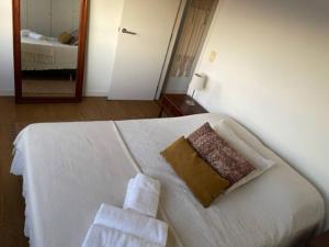 ein Schlafzimmer mit einem weißen Bett und Handtüchern darauf in der Unterkunft Encantador apartamento en Malvín in Montevideo