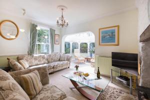 a living room with a couch and a tv at Glenside House in Carbis Bay