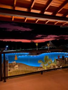 uma grande piscina à noite com luzes azuis em Vale Das Águas Fazenda Resort em Águas de Santa Barbara